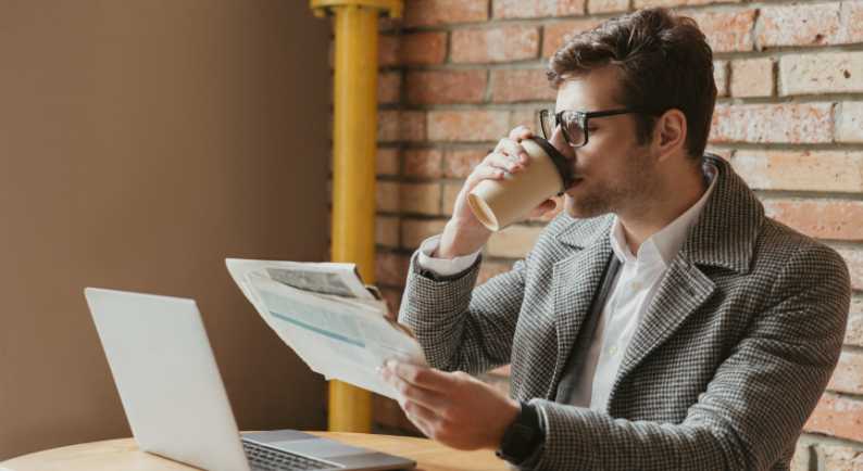 Imagem ilustrando investidor lendo notícias e tomando café